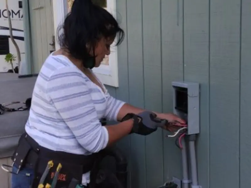 Licensed electrician wiring an exterior subpanel in Iola